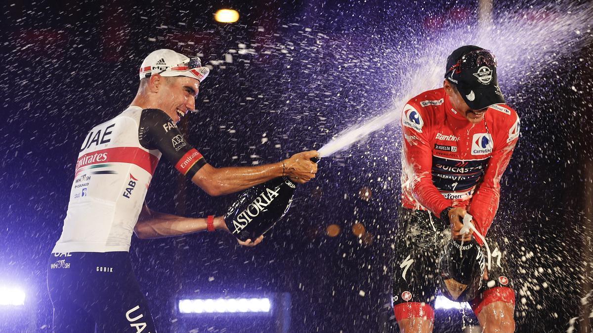 Juan Ayuso riega de cava en el podio de la Vuelta al ganador, Remco Evenepoel