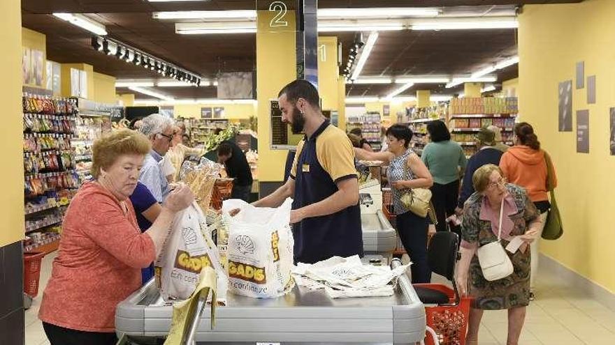 Clientes en las cajas del supermercado reabierto en Sada.