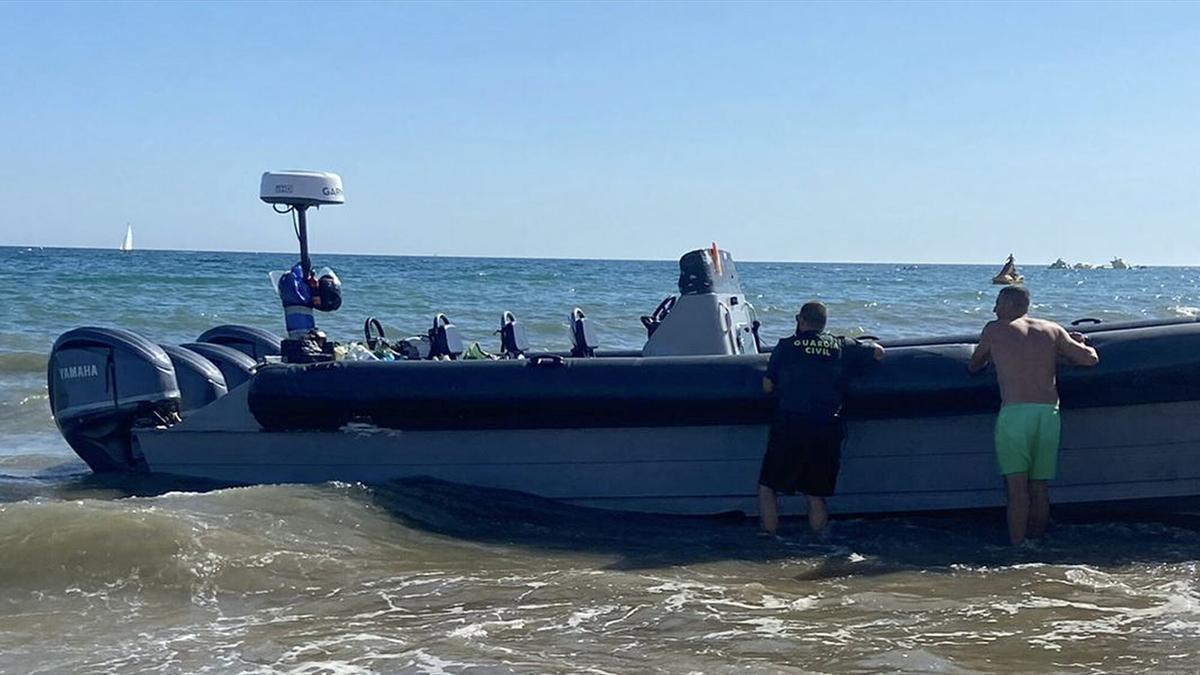 LA ANTILLA (HUELVA), 26/07/2024.- La Guardia Civil ha detenido a una persona que formaba parte de la tripulación de una embarcación semirrigida, de las que se utilizan en el narcotráfico, después de que encallara en la playa de La Antilla (Huelva) cuando trataba de eludir la acción policial. EFE/ Alfonso Belinchon