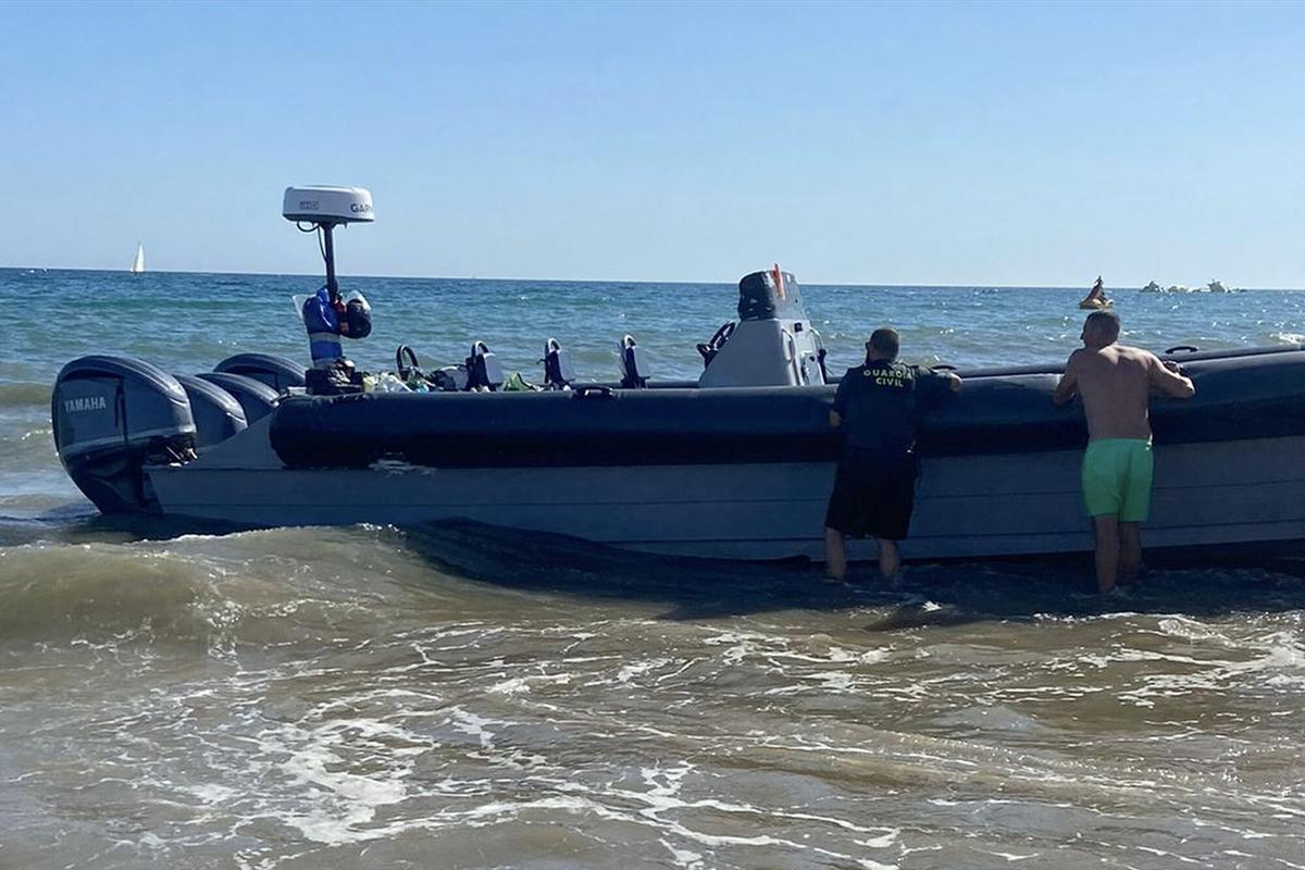 LA ANTILLA (HUELVA), 26/07/2024.- La Guardia Civil ha detenido a una persona que formaba parte de la tripulación de una embarcación semirrigida, de las que se utilizan en el narcotráfico, después de que encallara en la playa de La Antilla (Huelva) cuando trataba de eludir la acción policial. EFE/ Alfonso Belinchon