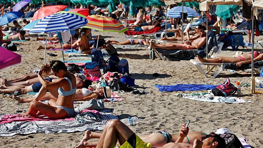 La playa de Benirràs, ayer por la tarde, llena de gente. | TONI ESCOBAR