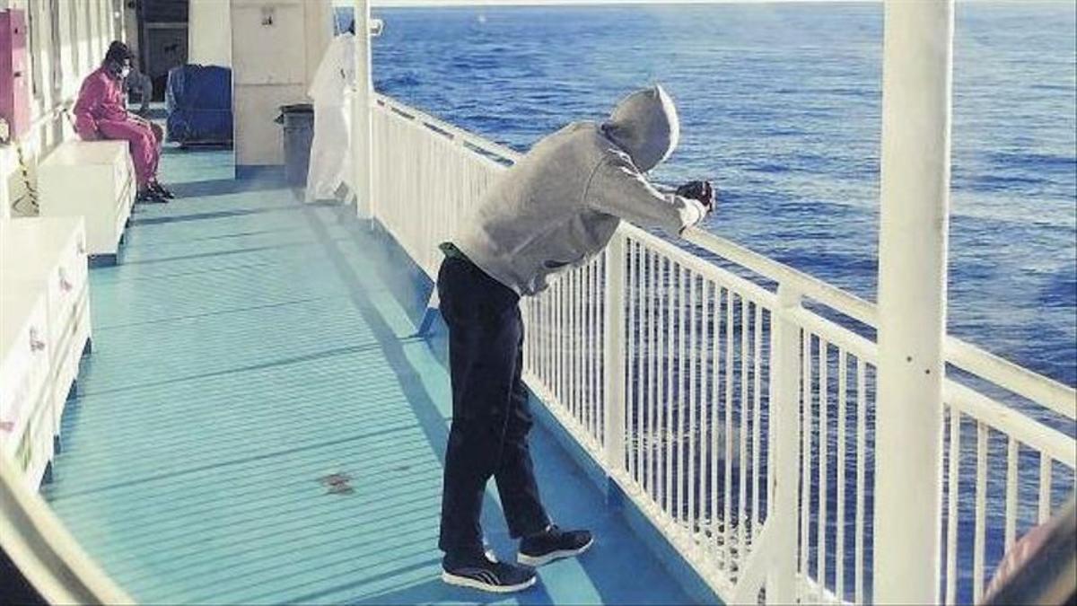 Un migrante, en el trayecto en barco hacia la península después de ser puesto en libertad.