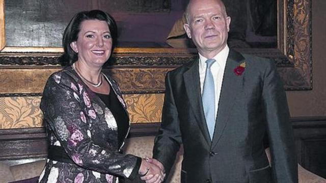 El titular de Exteriores británico saluda a la presidenta de Kosovo.