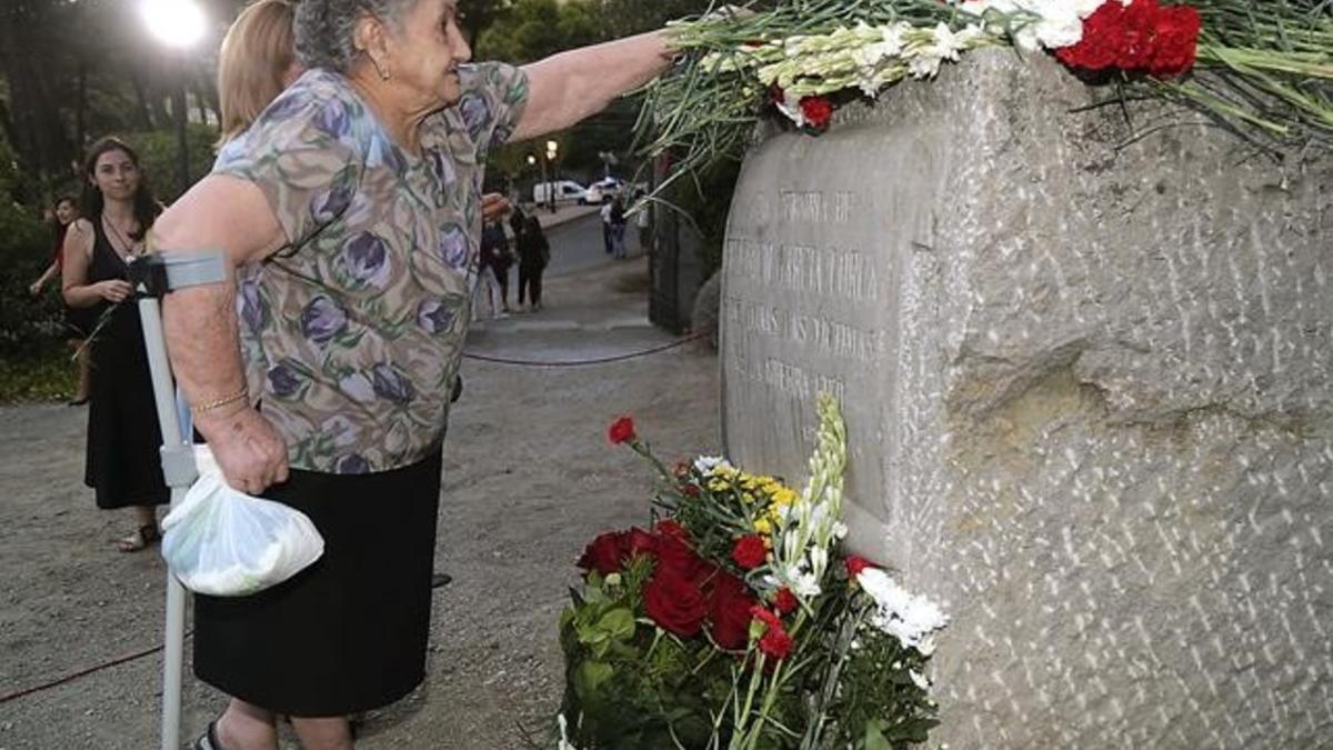 Una mujer deposita flores en el monolito dedicado a la memoria de Lorca en el homenaje a su 80 cumpleaños, este jueves.