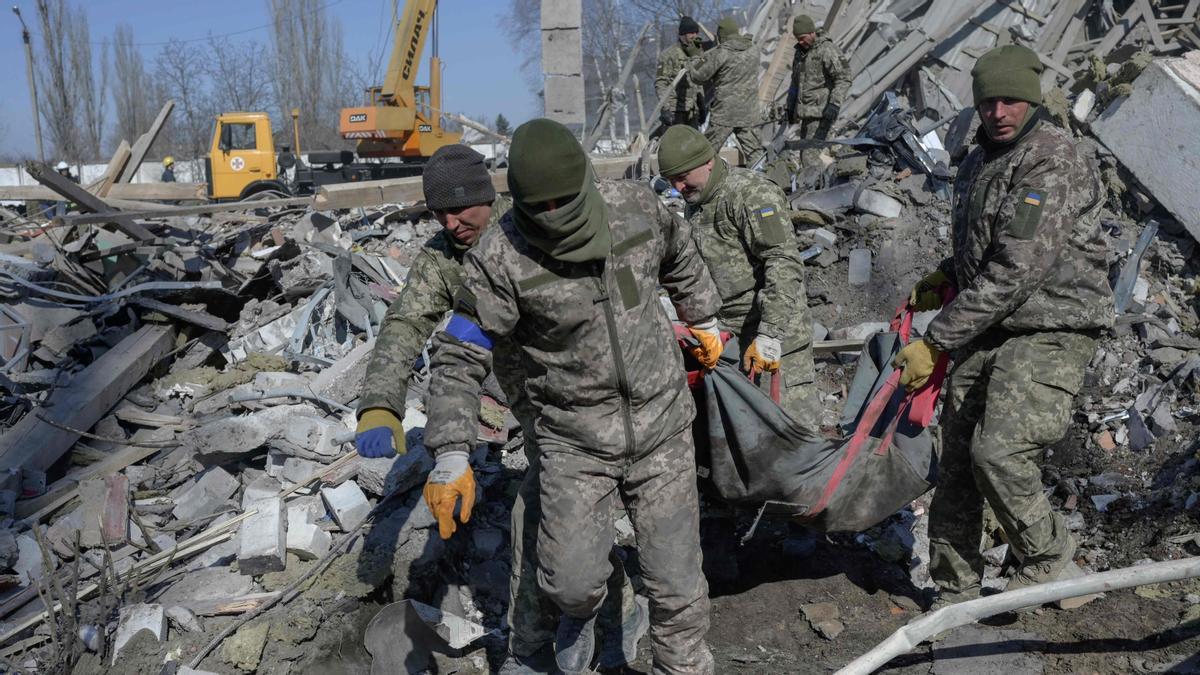 Soldados ucranianos trasladan el cuerpo sin vida de un compañero tras el bombardeo ruso de una escuela militar en Mykolaiv