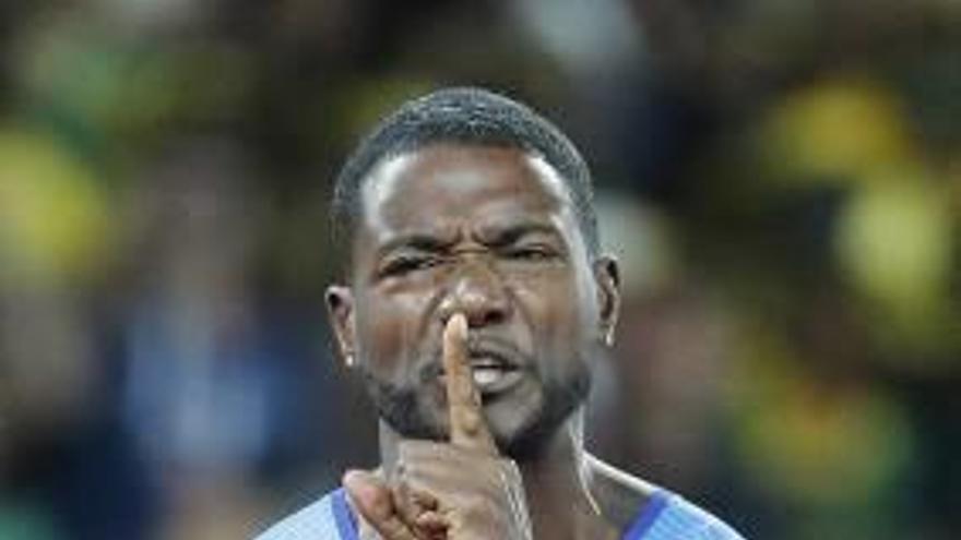 Justin Gatlin manda callar al estadio olímpico de Londres tras ganar el oro en los 100 metros; a la derecha, felicitación de Bolt.