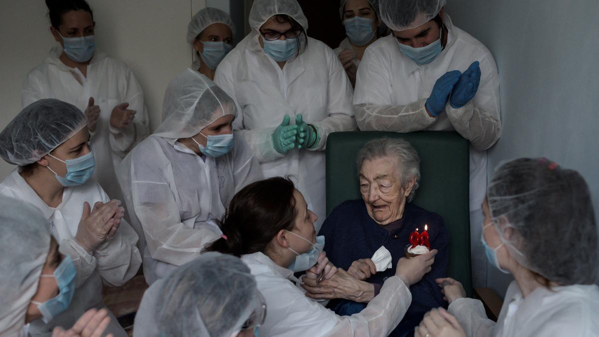 Imagen premiada en la que una mujer, Elena Pérez, celebra su 98 aniversario tras superar el COVID en una residencia de mayores de Ourense.