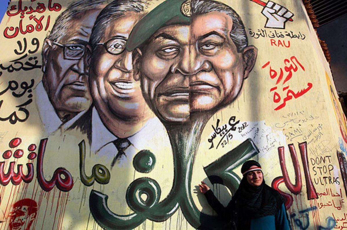 Una dona egípcia es fa una foto al costat d’un gran grafit de l’expresident Hosni Mubàrak a la plaça de Tahrir.