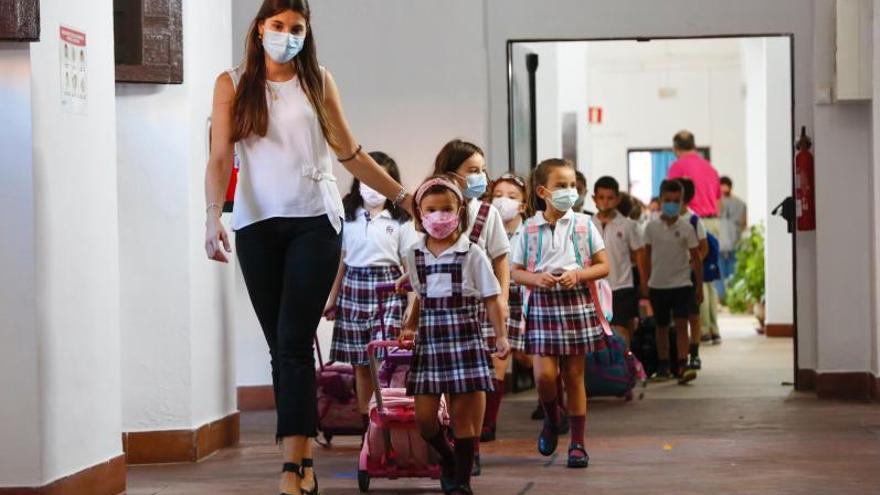 Una profesora guía a un grupo de escolares, todos con mascarillas, en un colegio de Córdoba.