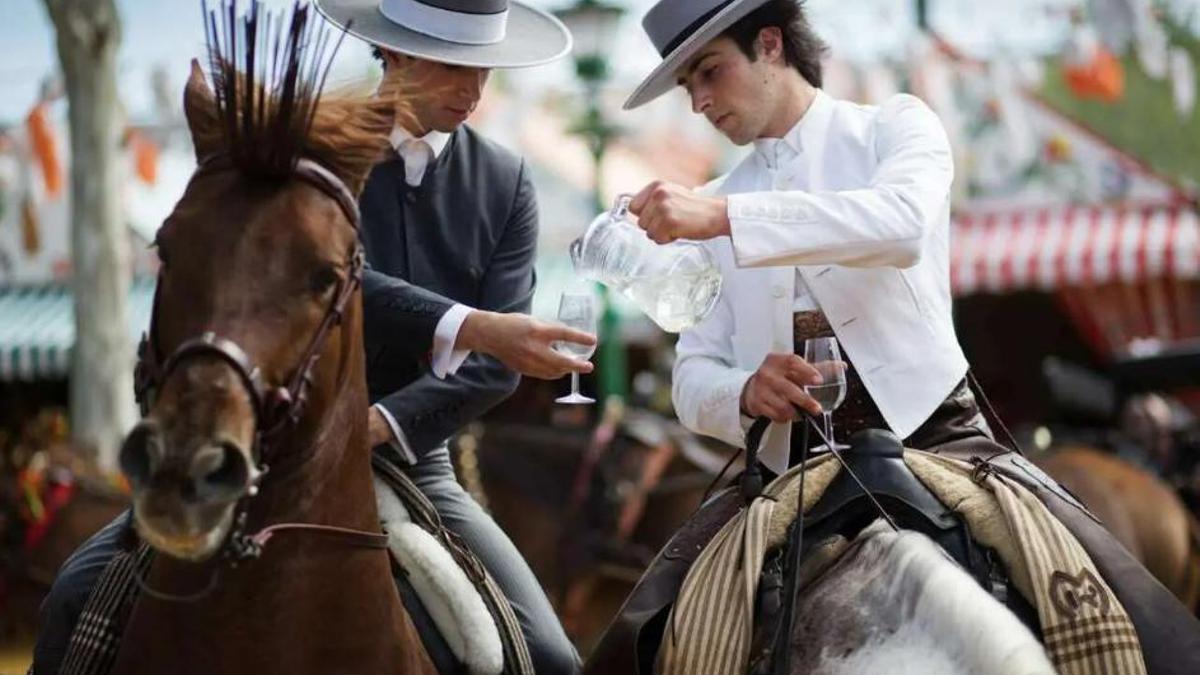 Los jinetes se sirven rebujito en la Feria de Sevilla