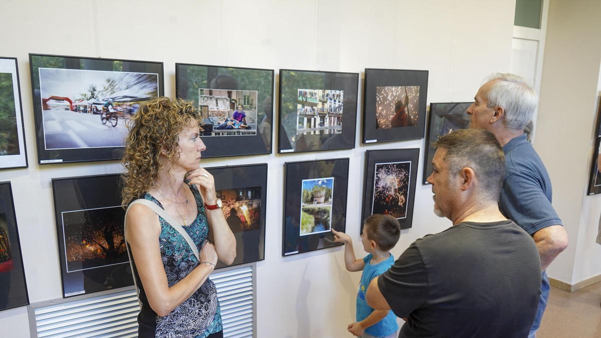 Uns visitants contemplen les fotografies d'una edició anterior del concurs