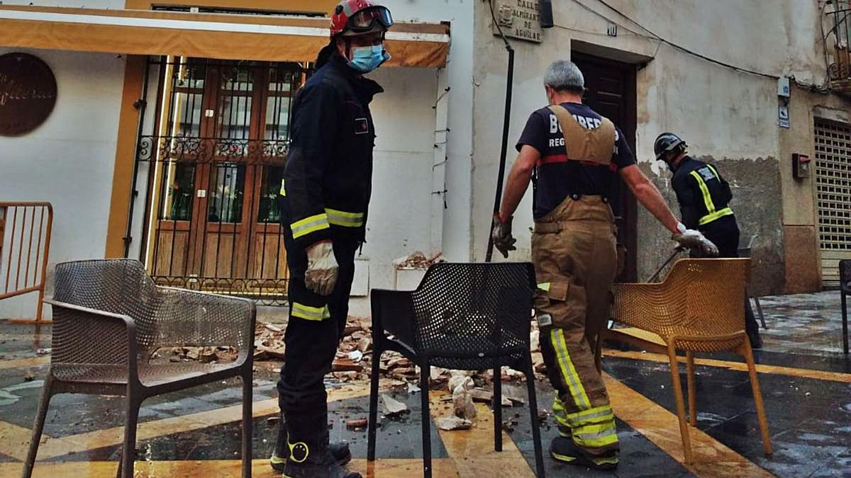 Los bomberos acordonaron la zona tras la caída de cascotes en la calle Corredera de Lorca. | L.O.