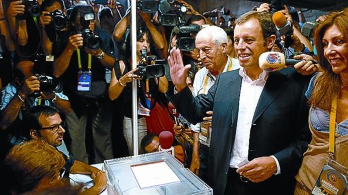Sandro Rosell, acompañado por su mujer, Marta, saluda tras votar.