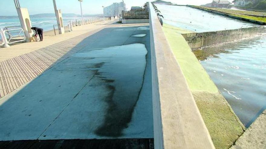 El paseo marítimo de Salinas, encharcado en la zona donde la fuente de Los Patos, a la derecha, rebosa agua.