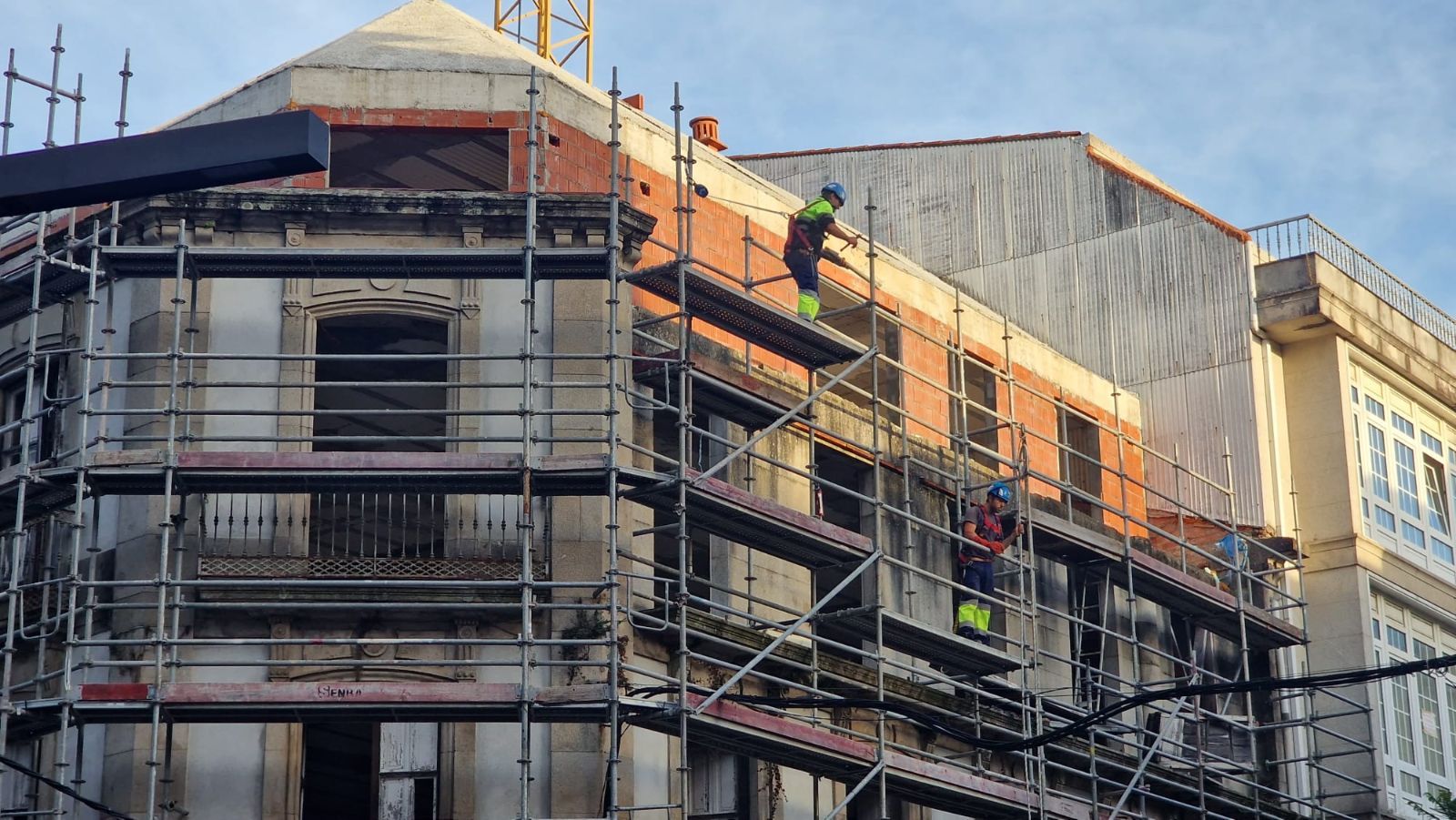 Así se desmontan los andamios en el edificio protegido del centro de Vilagarcía, cuya reconstrucción está a medias y fue paralizada por el Concello hace un año.