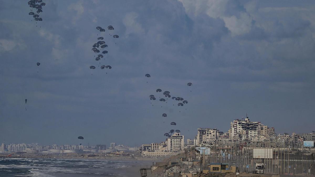 Ayuda humanitaria lanzada por aviones de EEUU desciende sobre la playa y el mar en el norte de la Franja de Gaza, este jueves