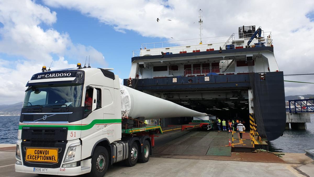 Un camión introduce una pala eólico en un buque, en Bouzas