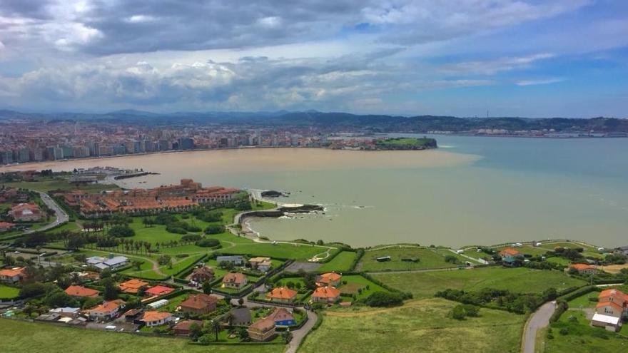 La imagen de la bahía de Gijón, teñida de marrón, tomada por un parapentista.