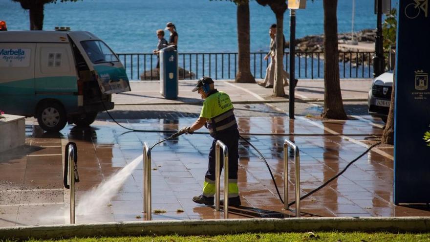 Un operario baldea un tramo del paseo marítimo de Marbella