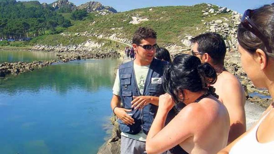 Uno de los guías voluntarios de Matrix, con un grupo de turistas en el &quot;lago dos nenos&quot;, en Cíes.