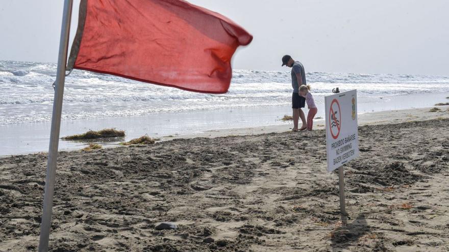 Un padre y una hija observan la orilla de Playa del Inglés, con bandera roja, archivo. | | JUAN CASTRO