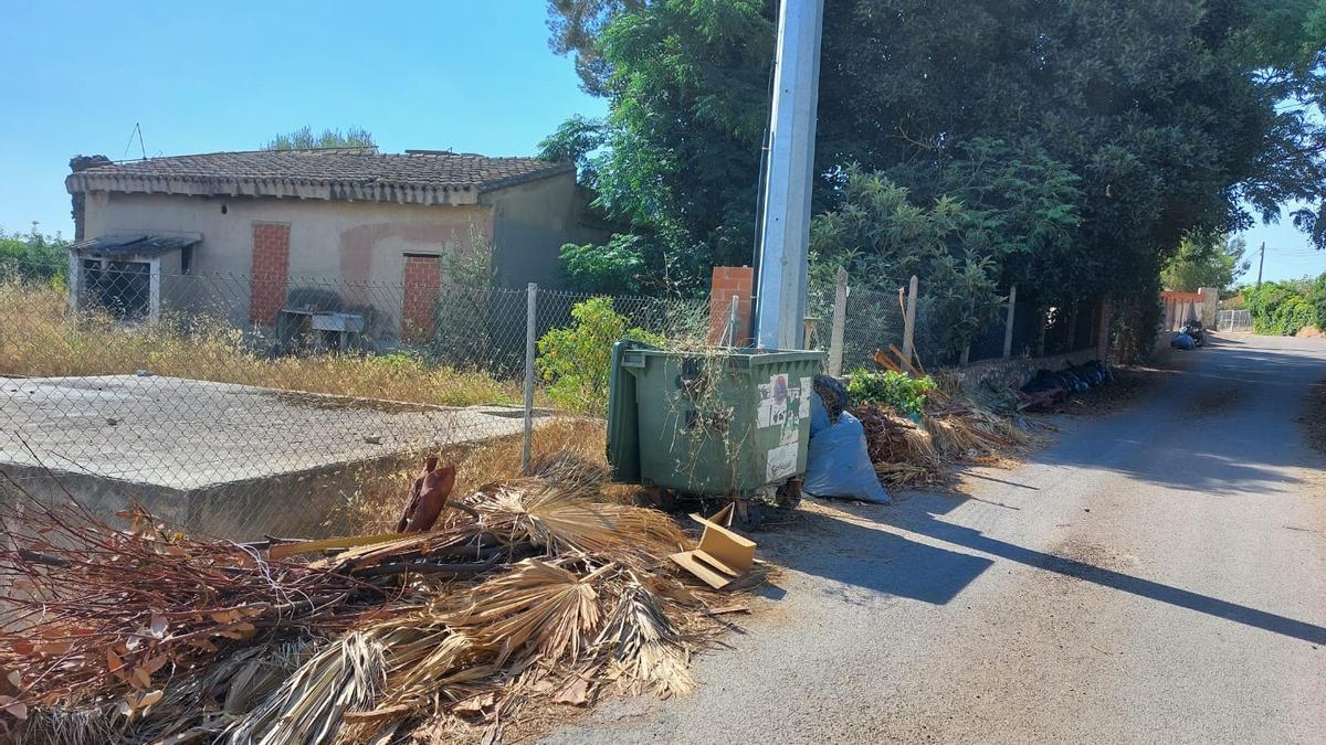 Restos de poda junto a un contenedor en la urbanización de Bétera Camí de Paterna