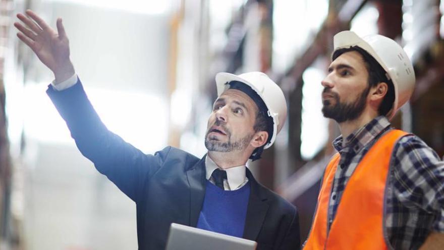 Dos empleados conversan en el trabajo.