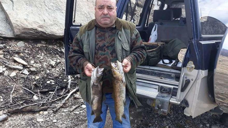 Un pescador de Puebla muestra los dos extraordinarios ejemplares de truchas pescados ayer.