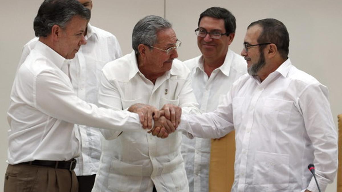 Raúl Castro sostiene las manos estrechadas del presidente de Colombia, Juan Manuel Santos, y del líder de las FARC, Rodrigo Londoño, alias 'Timochenko', este miércoles en La Habana.