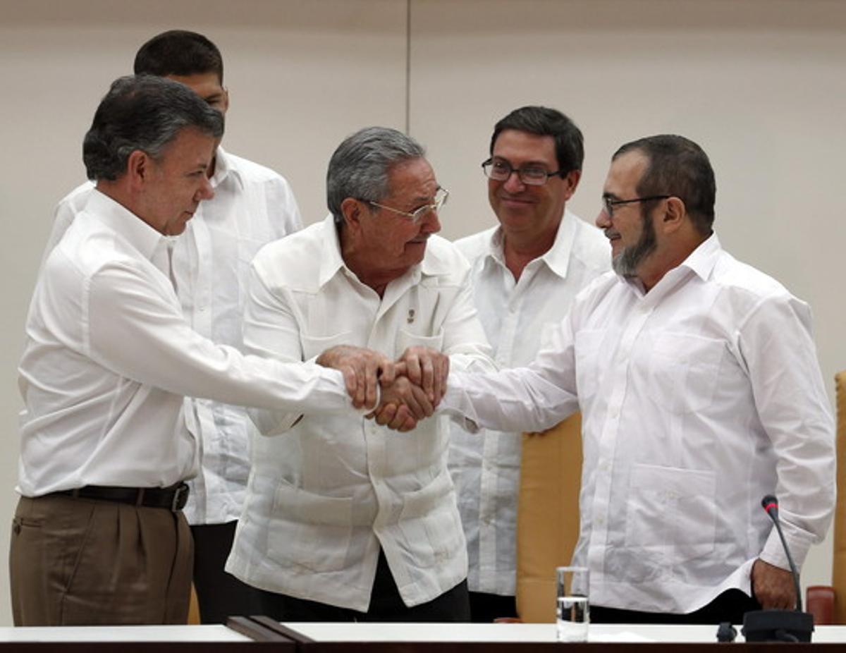 Raúl Castro sosté les mans estretes del president de Colòmbia, Juan Manuel Santos, i del líder de les FARC, Rodrigo Londoño, àlies ’Timochenko’, aquest dimecres a l’Havana.