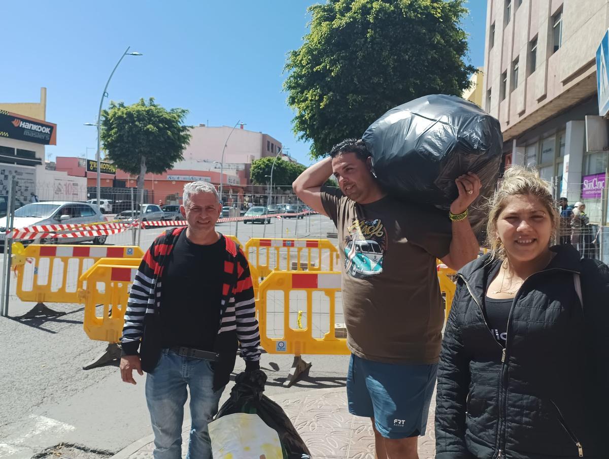 Yoel, papá de uno de los bebés,carga con la bolsa al hombroc con Rolando y Yanet.