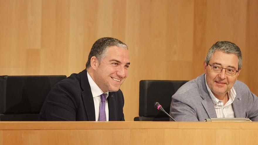 Elías Bendodo, a la izquierda, sonríe durante el pleno.