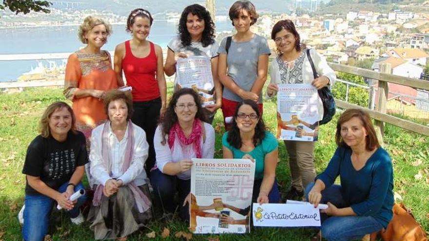 Las bibliotecarias de los centros participantes en la iniciativa y los colaboradores con el cartel de la campaña. // Faro