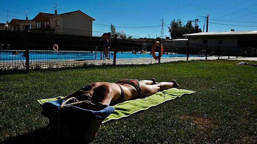 Una joven toma el sol en la piscina de la provincia. | Emilio Fraile