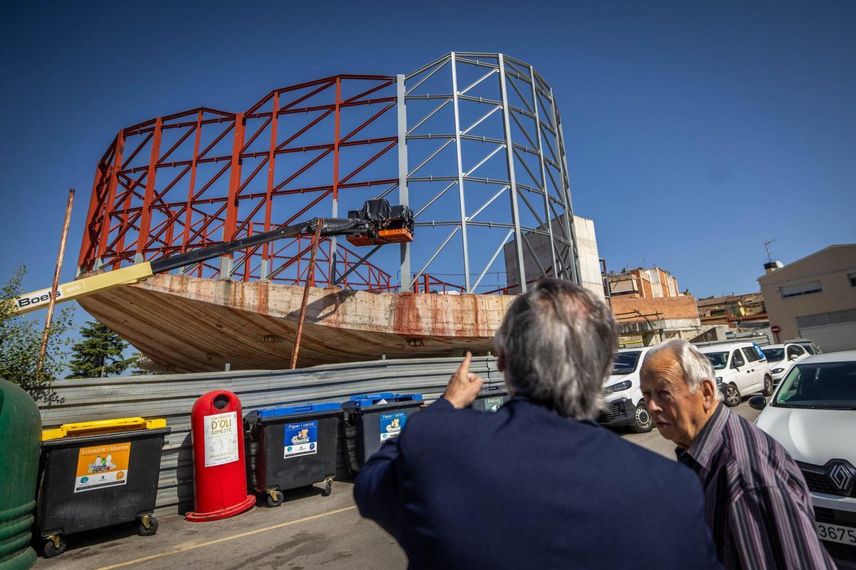 El exalcalde de Sant Esteve Sesrovires, Enric Carbonell, muestra a un vecino la obra de la nueva biblioteca municipal.