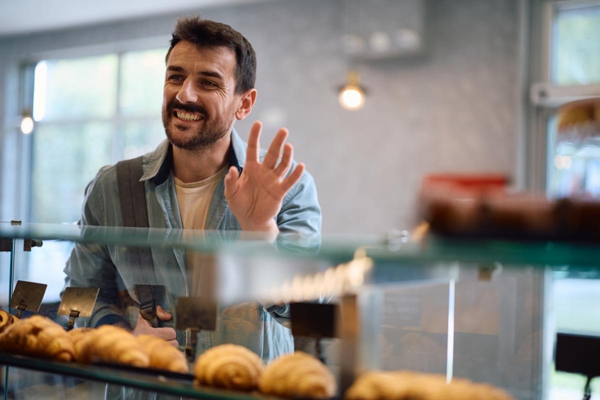 Un hombre saluda al entrar a un establecimiento.