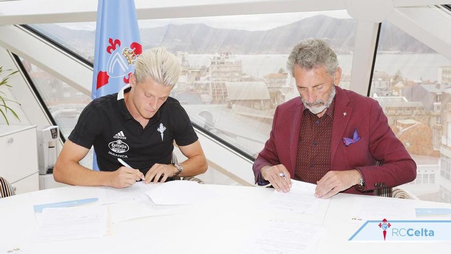 Jensen y Carlos Mouriño firman los documentos del contrato del jugador.