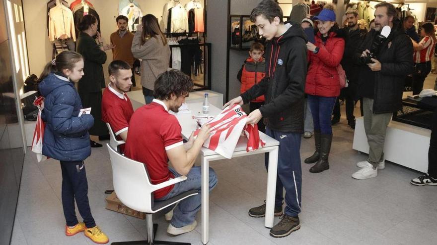Álex Corredera firma a Víctor Manuel Álvarez, ante la mirada de Dubasin y la pequeña Laura Álvarez. | LUCAS CID