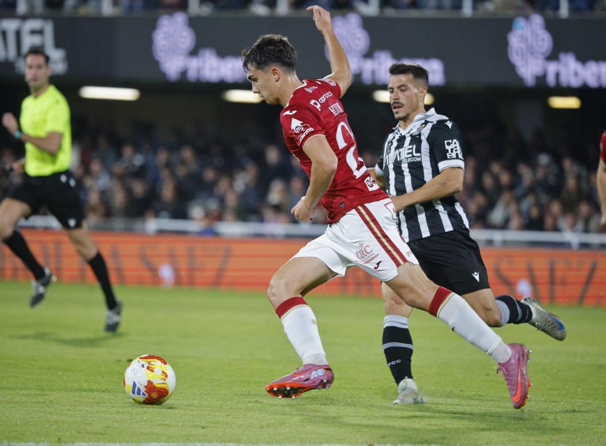 Héctor Pérez se dispone a golpear el balón ante Chiki en el derbi FC Cartagena-Real Murcia. | IVÁN URQUÍZAR