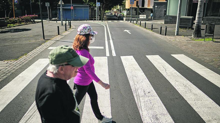 Dos peatones cruzan una calle.