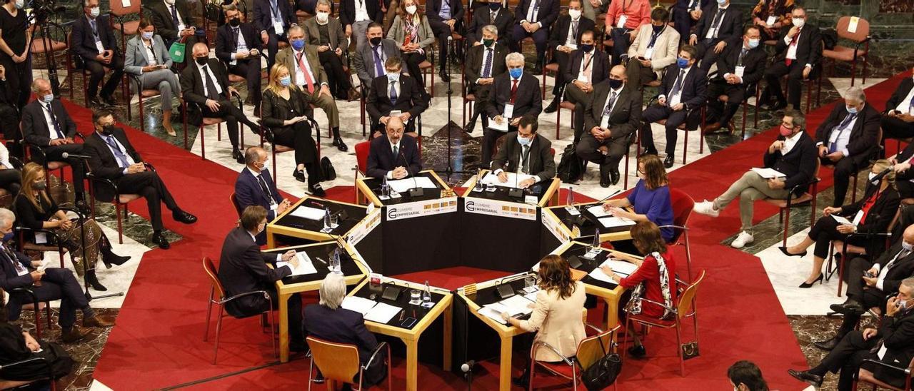 Los líderes patronales y políticos, situados en la mesa redonda y rodeados de representantes empresariales de las cuatro autonomías. | EUROPA PRESS
