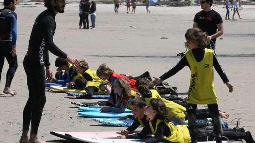 Niños a punto de recibir el bautismo de surf en Patos.  // J. De Arcos