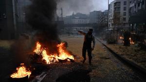 Un agricultor levanta el brazo junto a una paca de paja en llamas en las calles de Bruselas, este lunes.