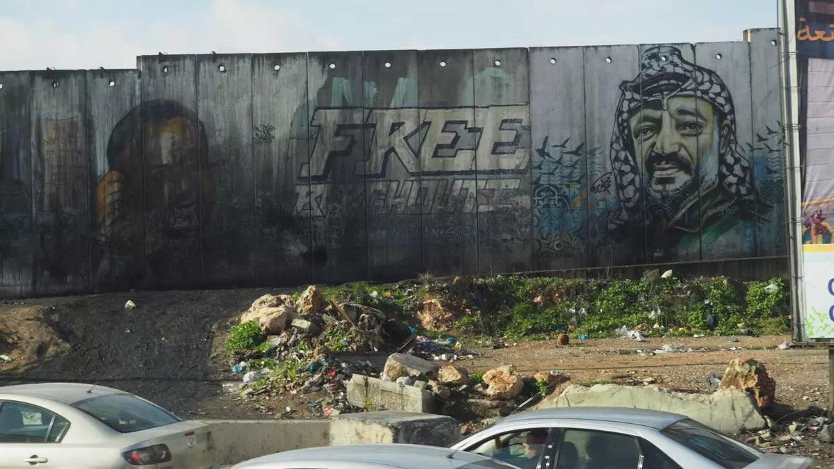 Un grafiti con el rostro del líder palestino Yasir Arafat en el muro de Cisjordania, junto al puesto de control de Qalandia, cerca de Ramala. /