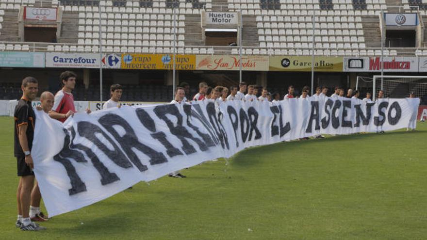 Los jugadores y el técnico del Cartagena cogieron la pancarta que realizó la federación de peñas y que dice que &#039;Moriremos por el ascenso&#039; antes del entrenamiento de ayer