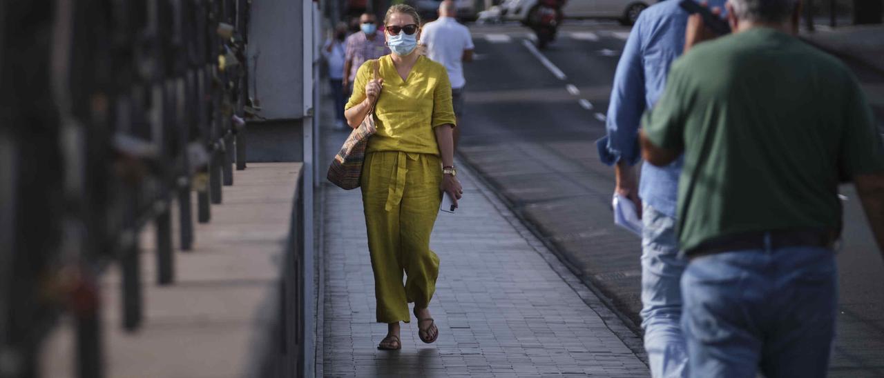 Una mujer camina con mascarilla por el puente Galcerán.