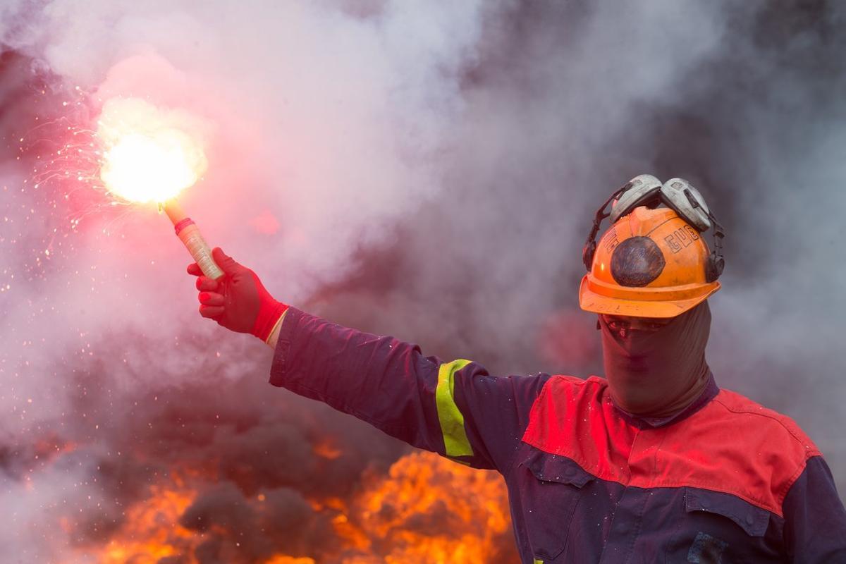 Un trabajador de Alcoa San Cibrao enciende una bengala durante una manifestación en la que han cortado la Autopista A6 con la quema de neumáticos, en Outeiro de Rei, Lugo, Galicia (España), a 22 de septiembre de 2020. Con la concentración, los trabajadores de Alcoa quieren reivindicar la importancia de su actividad en la comarca de A Mariña y pedir un acuerdo antes del domingo 27 de septiembre, dÃa en el que finaliza el plazo de las negociaciones para la venta de la factorÃa al grupo Liberty House, que permita inversión para mantener la industria y los puestos de trabajo. Un trabajador de Alcoa San Cibrao enciende una bengala durante una manifestación en la que han cortado la Autopista A6 con la quema de neumáticos, en Outeiro de Rei, Lugo, Galicia (España), a 22 de septiembre de 2020. Con la concentración, los trabajadores de Alcoa quieren reivindicar la importancia de su actividad en la comarca de A Mariña y pedir un acuerdo antes del domingo 27 de septiembre, dÃa en el que finaliza el plazo de las negociaciones para la venta de la factorÃa al grupo Liberty House, que permita inversión para mantener la industria y los puestos de trabajo.