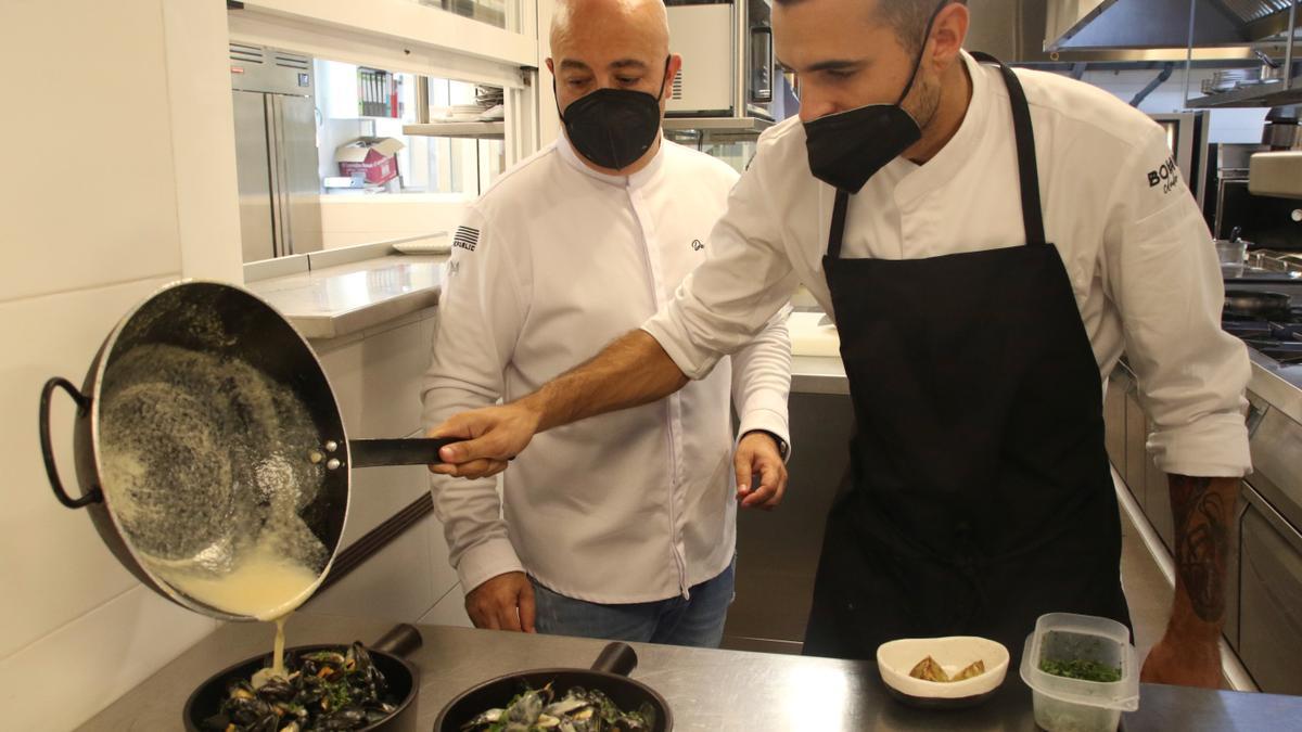 El chef malagueño, Diego del Río (i), en la cocina de su restaurante Boho en Marbella supervisa la preparación de unos mejillones en salsa de coco y cítricos, uno de los platos estrella del restaurante