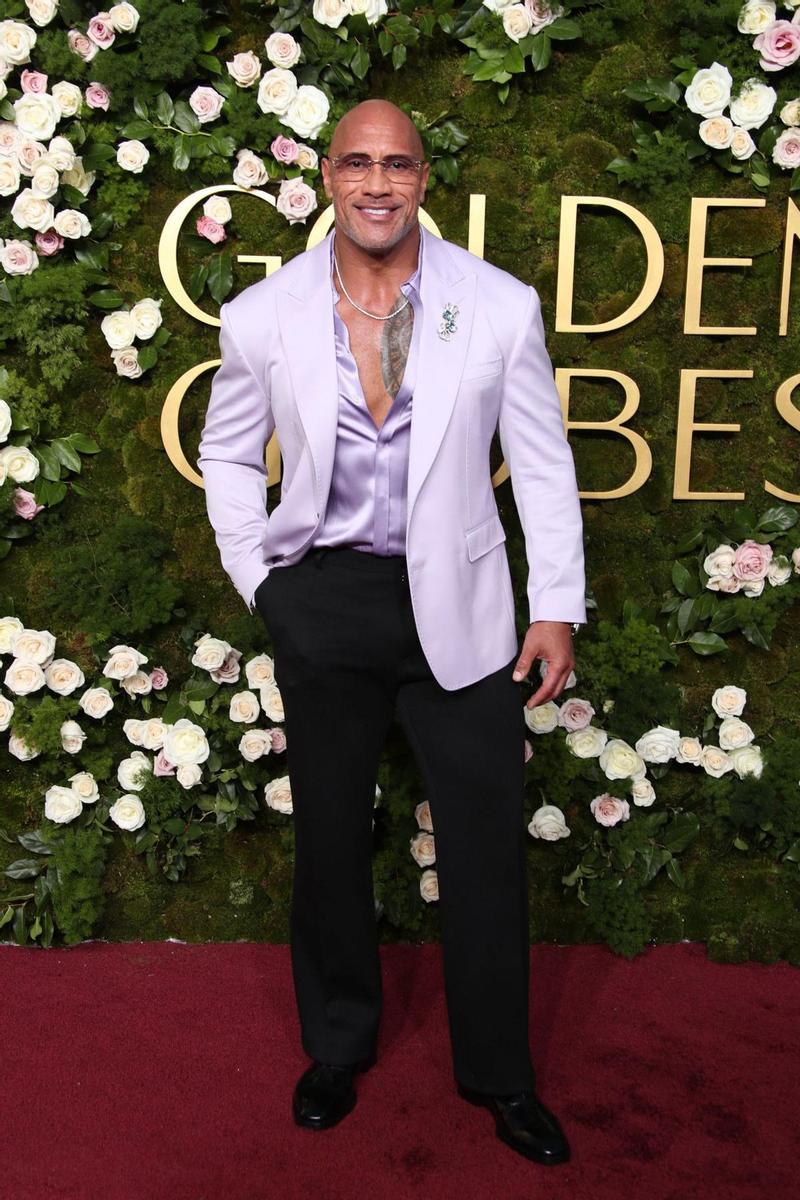 Dwayne Johnson, atrevido, con camisa abierta por el pecho, americana morada y gafitas que solo quedan bien a 'La Roca'