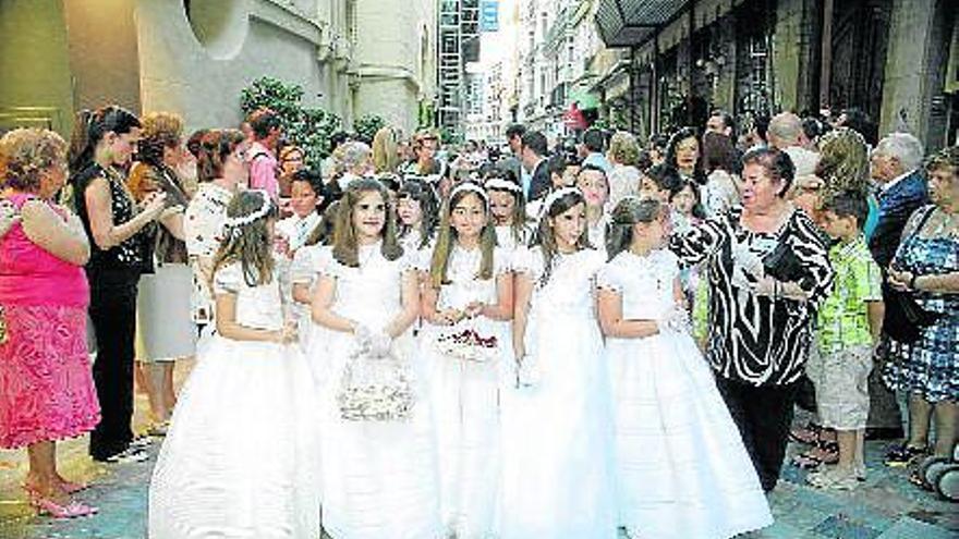 Decenas de niñas vestidas de Primera Comunión, ayer en la calle Mayor durante la procesión del Corpus